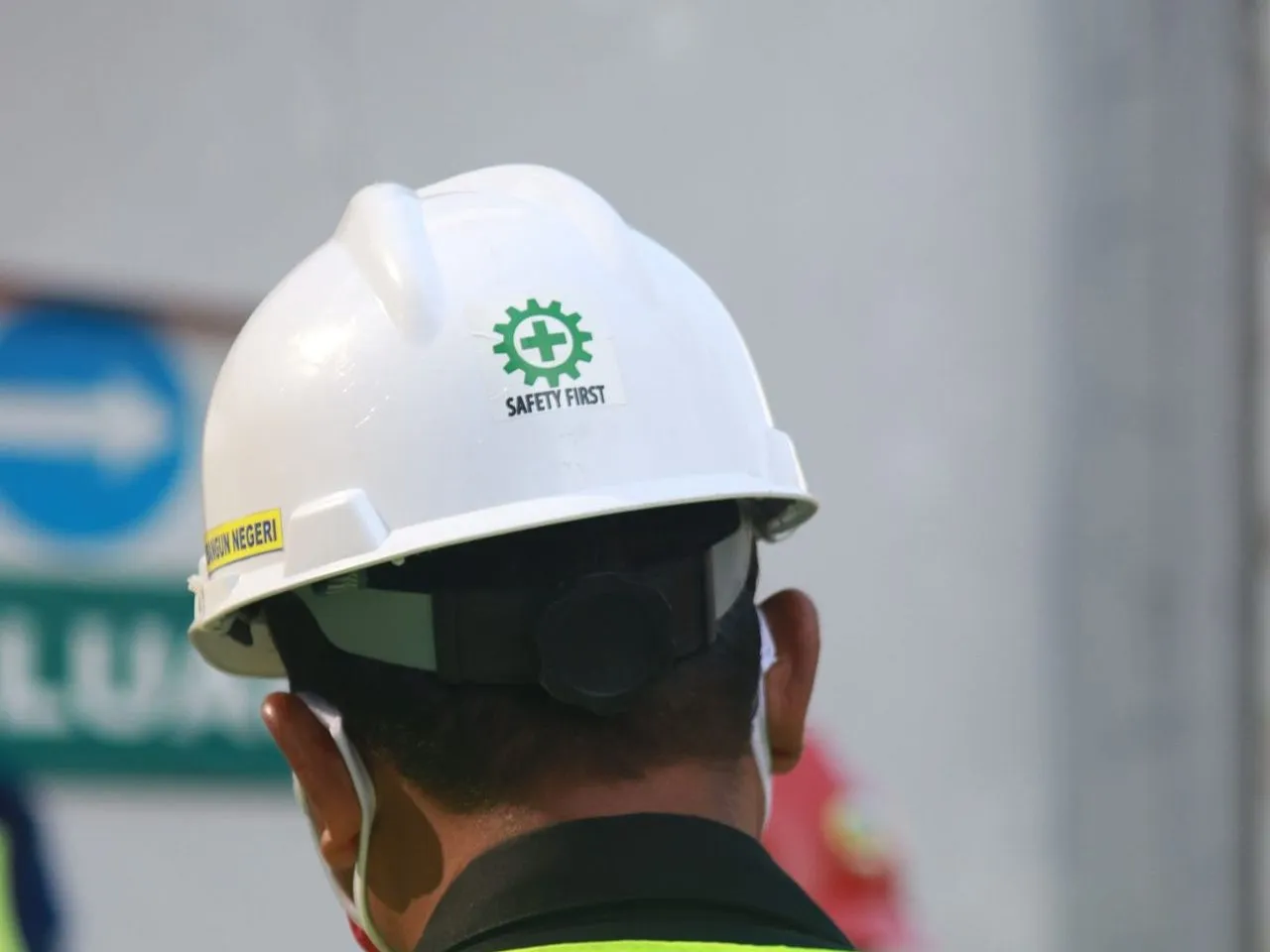 Pekerja berhelm putih dan rompi keselamatan di lokasi proyek