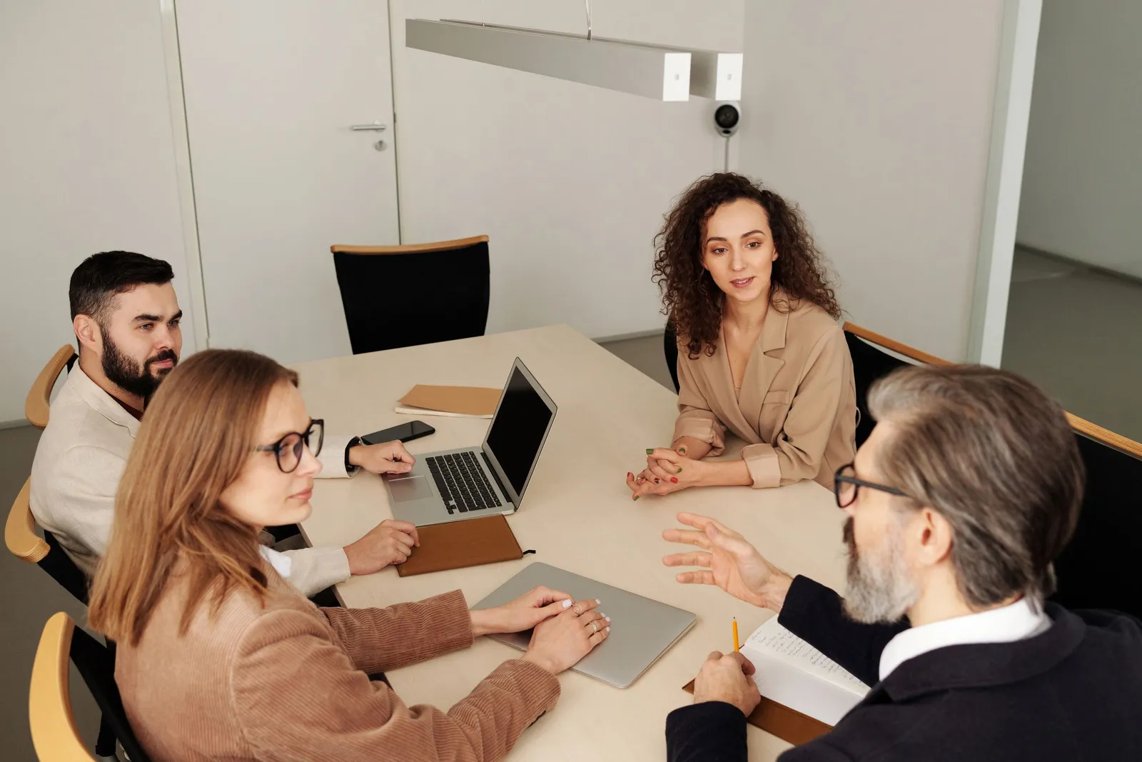 Rapat tim di meja kantor dengan laptop