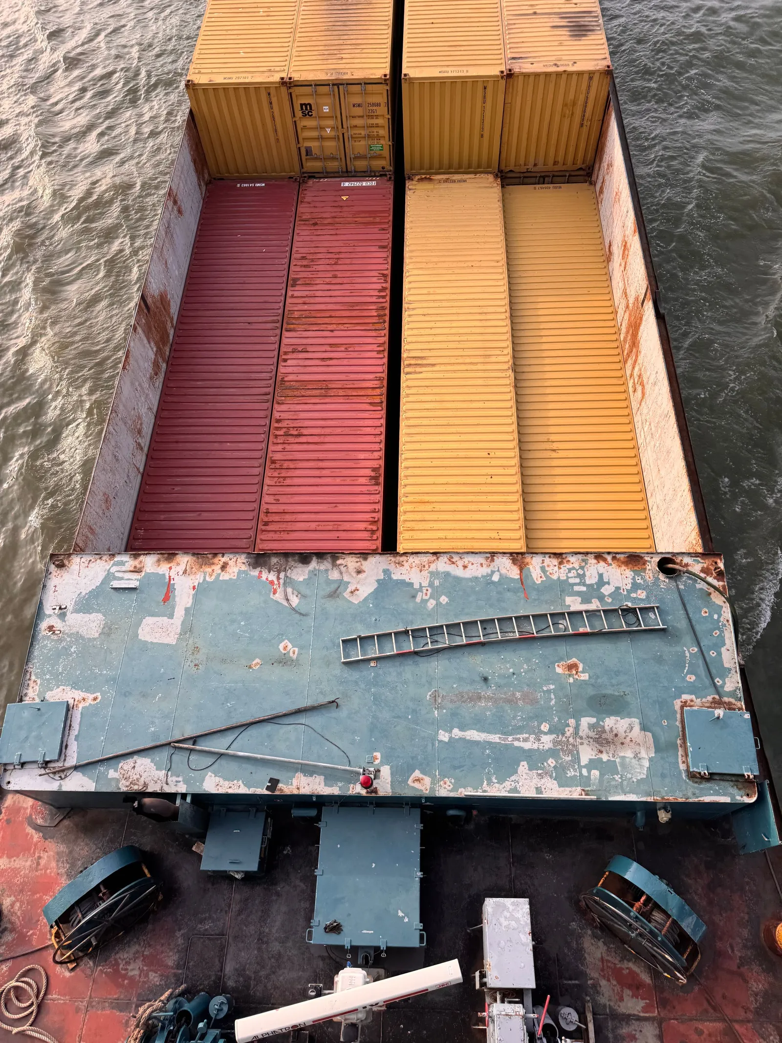 Peti kemas merah dan kuning di dek kapal dilihat dari atas