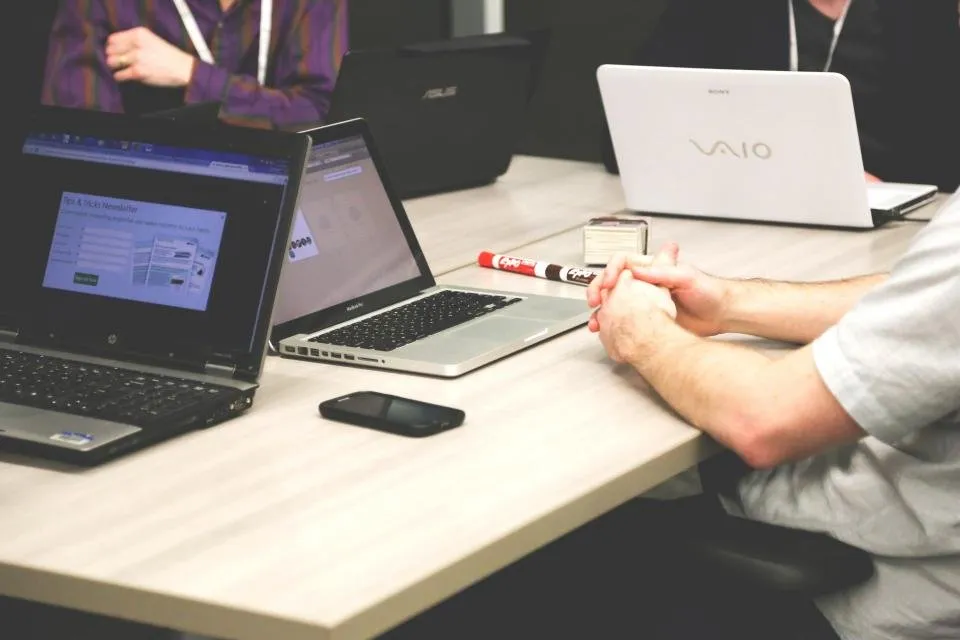 Peserta bekerja dengan laptop di meja pelatihan