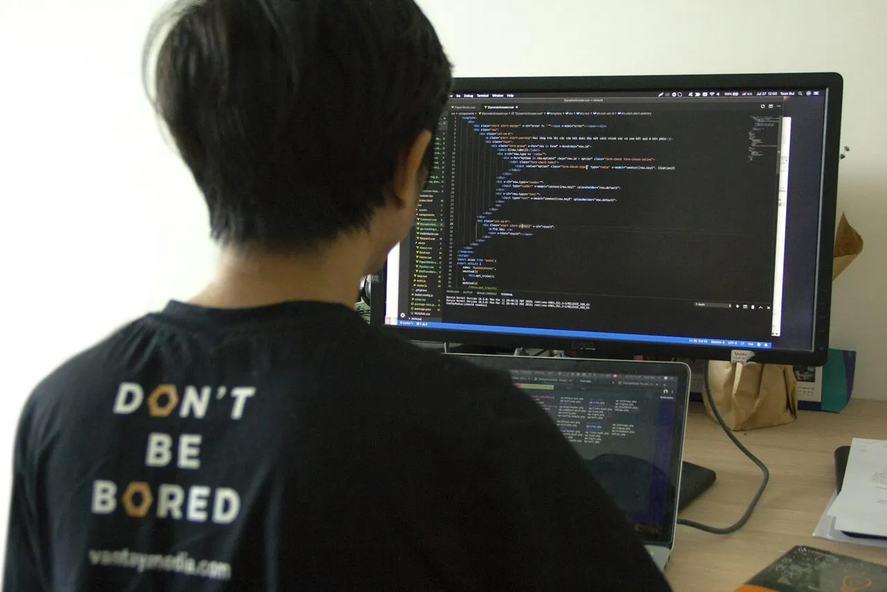 Programmer menulis kode di depan monitor