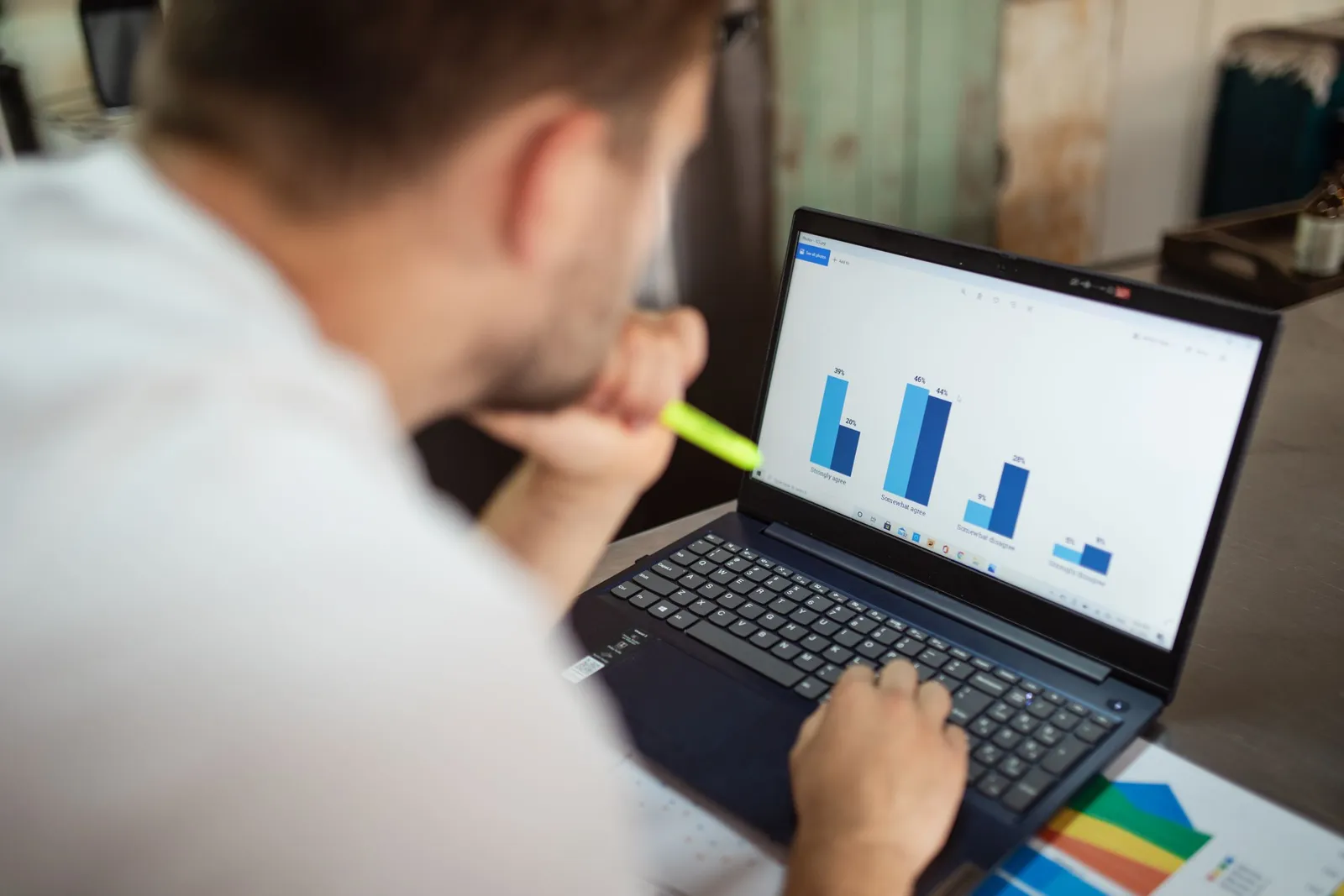 Pria meninjau grafik batang di laptop