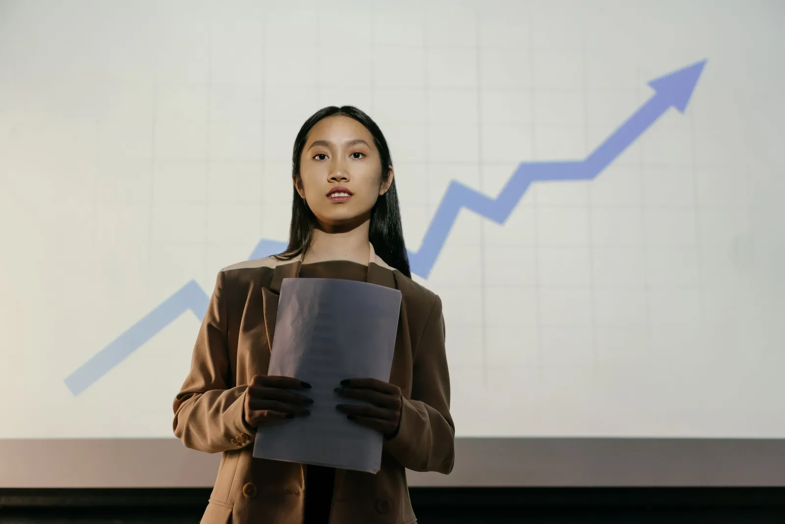 Pebisnis perempuan di depan grafik naik