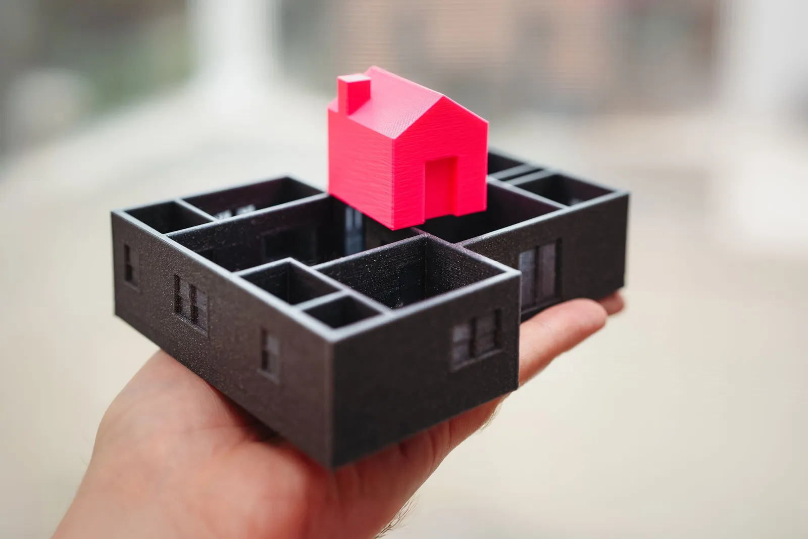 Tangan memegang maket rumah cetak 3D