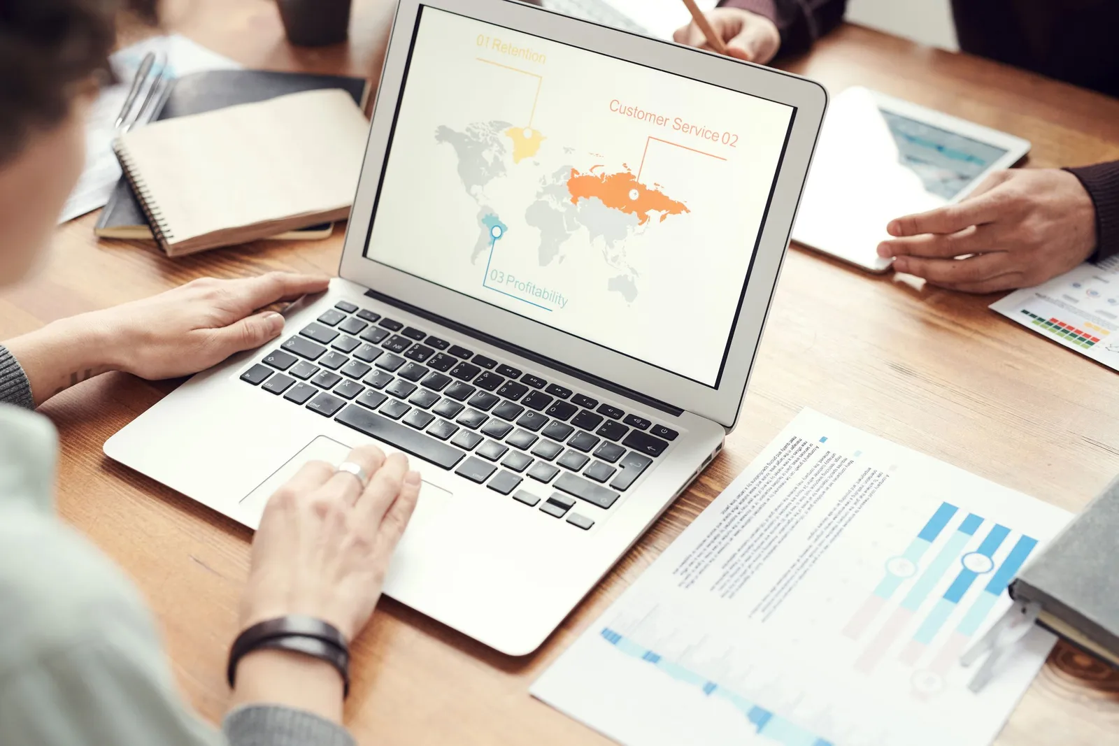 Tangan bekerja di laptop dengan laporan grafik
