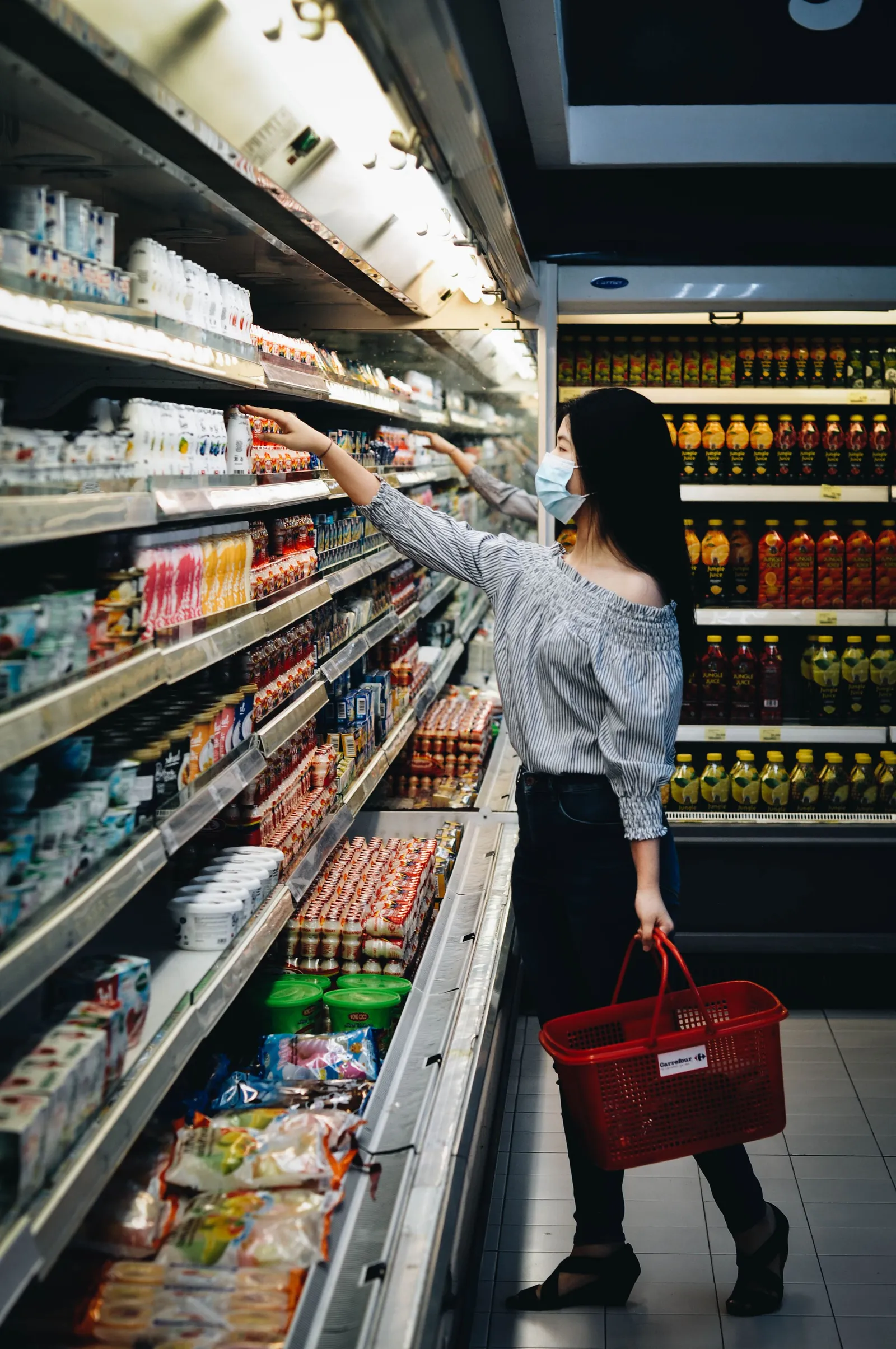 Perempuan memilih produk di rak supermarket