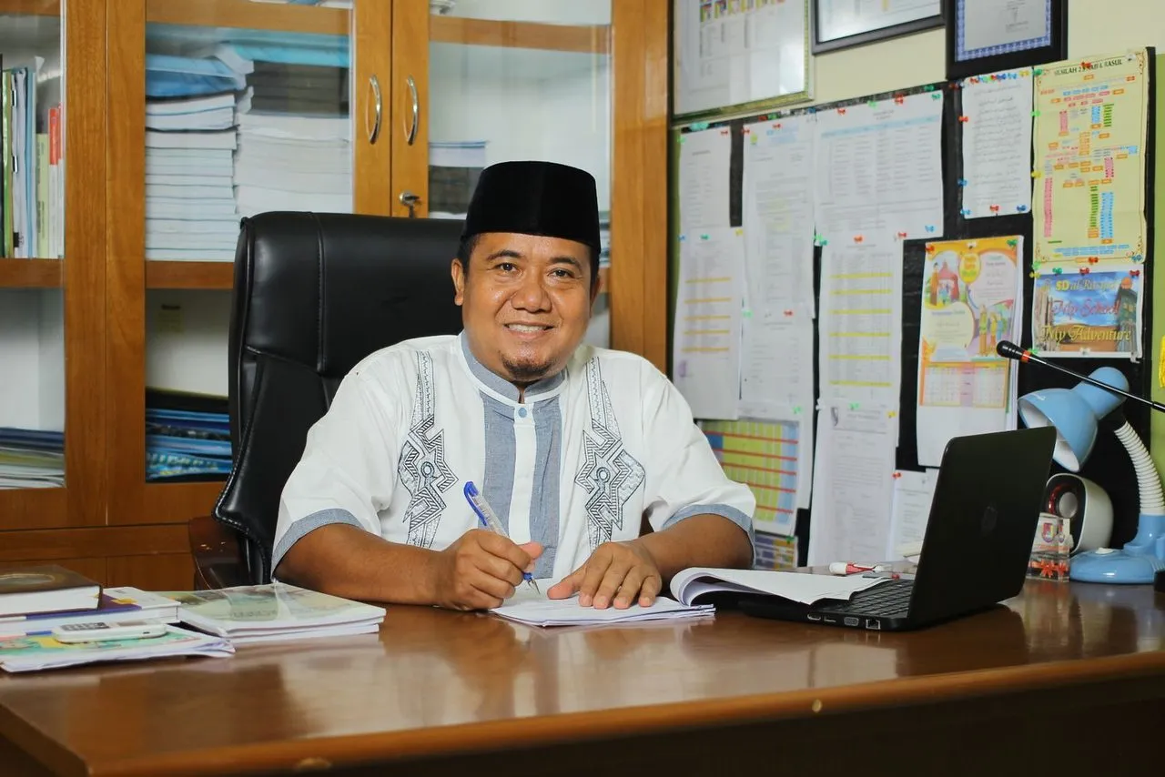 Pegawai tersenyum di meja kerja kantor dengan dokumen