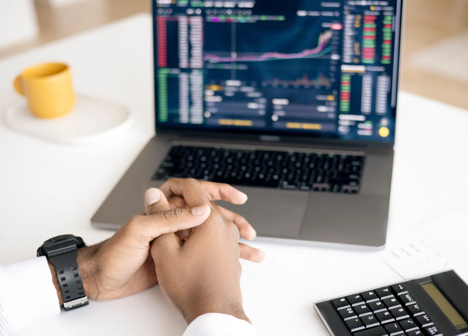 Grafik pasar di laptop dan ponsel di meja kerja
