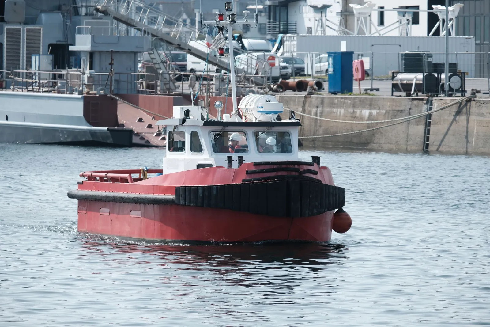 Kapal tunda merah melintas di perairan pelabuhan