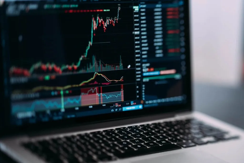 Laptop menampilkan grafik pergerakan harga pasar