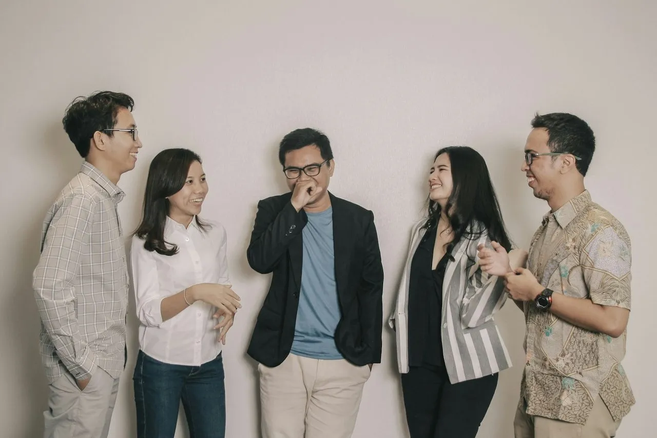 Tim kantor berbincang santai di ruang kerja