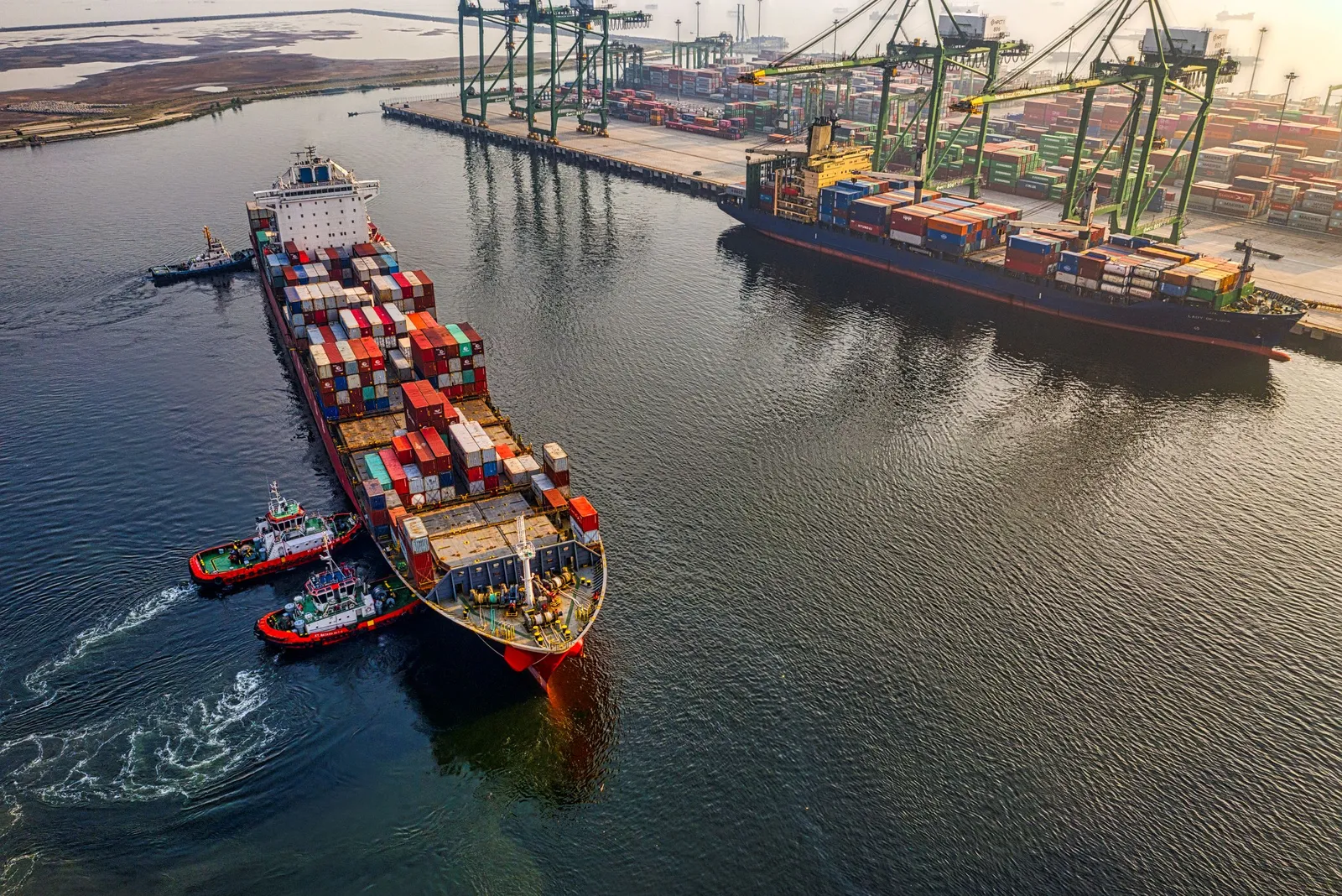 Kapal kontainer dibantu kapal tunda memasuki terminal pelabuhan