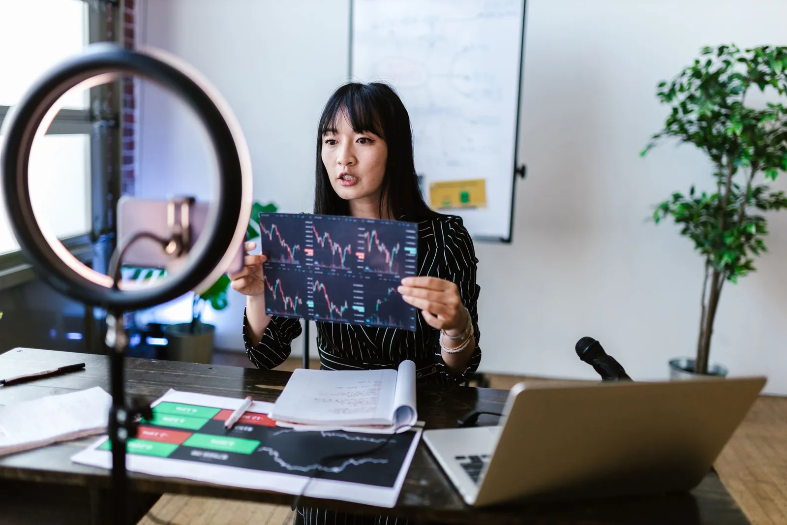 Perempuan memegang lembar grafik analisis data