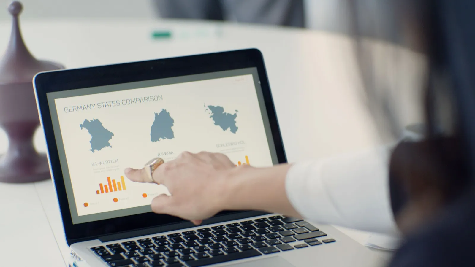 Tangan menunjuk dasbor data di laptop