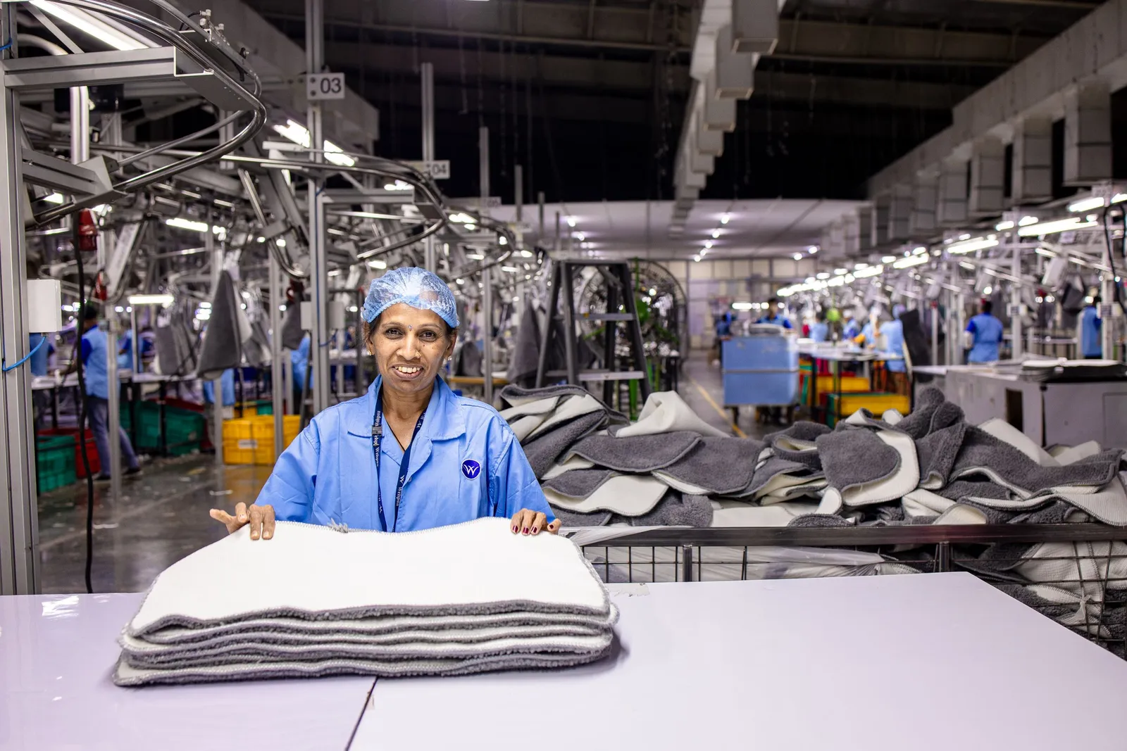 Petugas kendali mutu memeriksa produk tekstil di pabrik