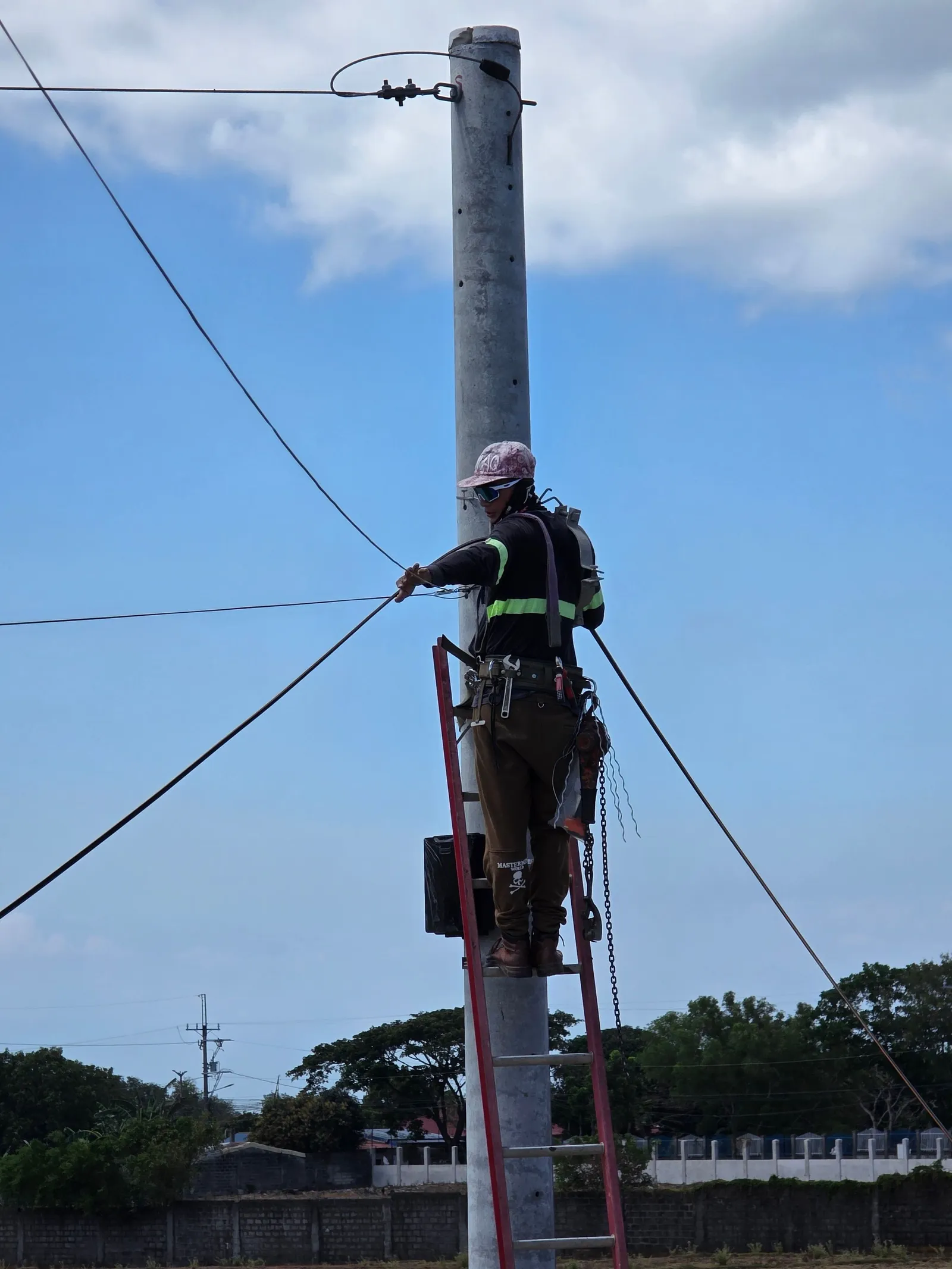 Petugas jaringan memanjat tiang listrik