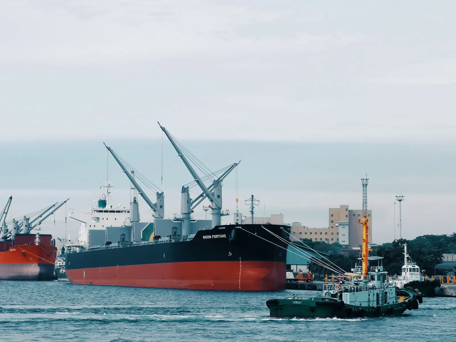 Kapal kargo dibantu kapal tunda di pelabuhan