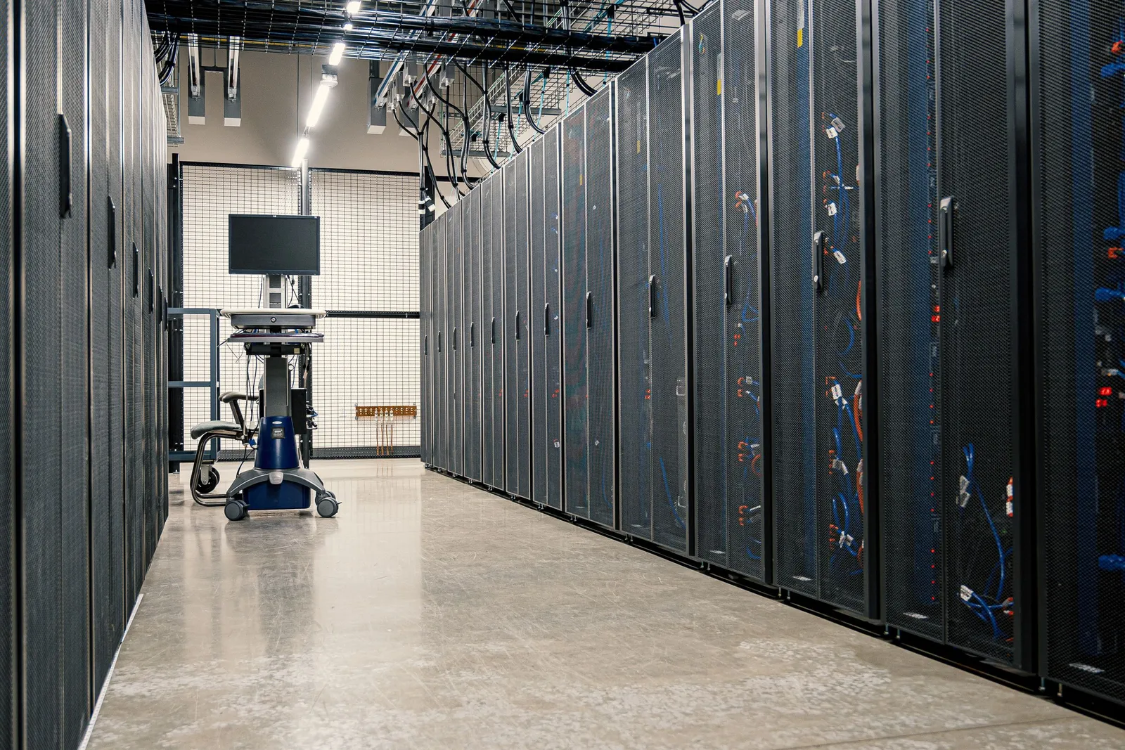Lorong ruang server dengan deretan rak