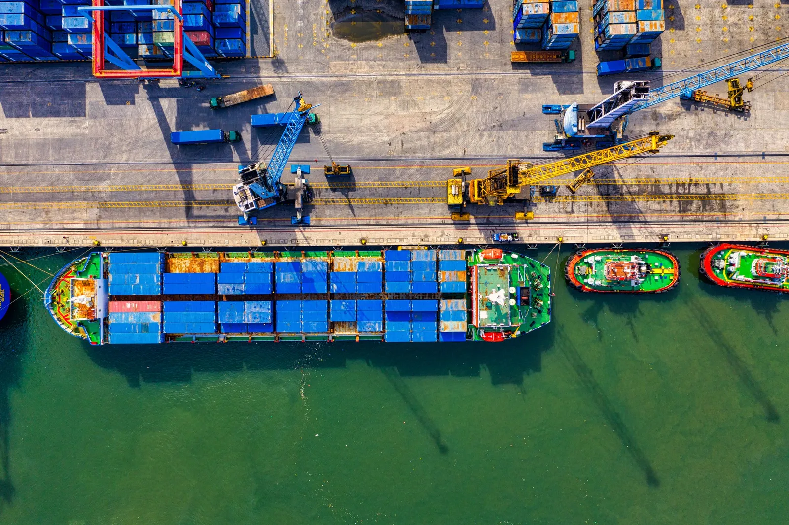 Kapal kontainer dan kapal tunda di dermaga dilihat dari udara