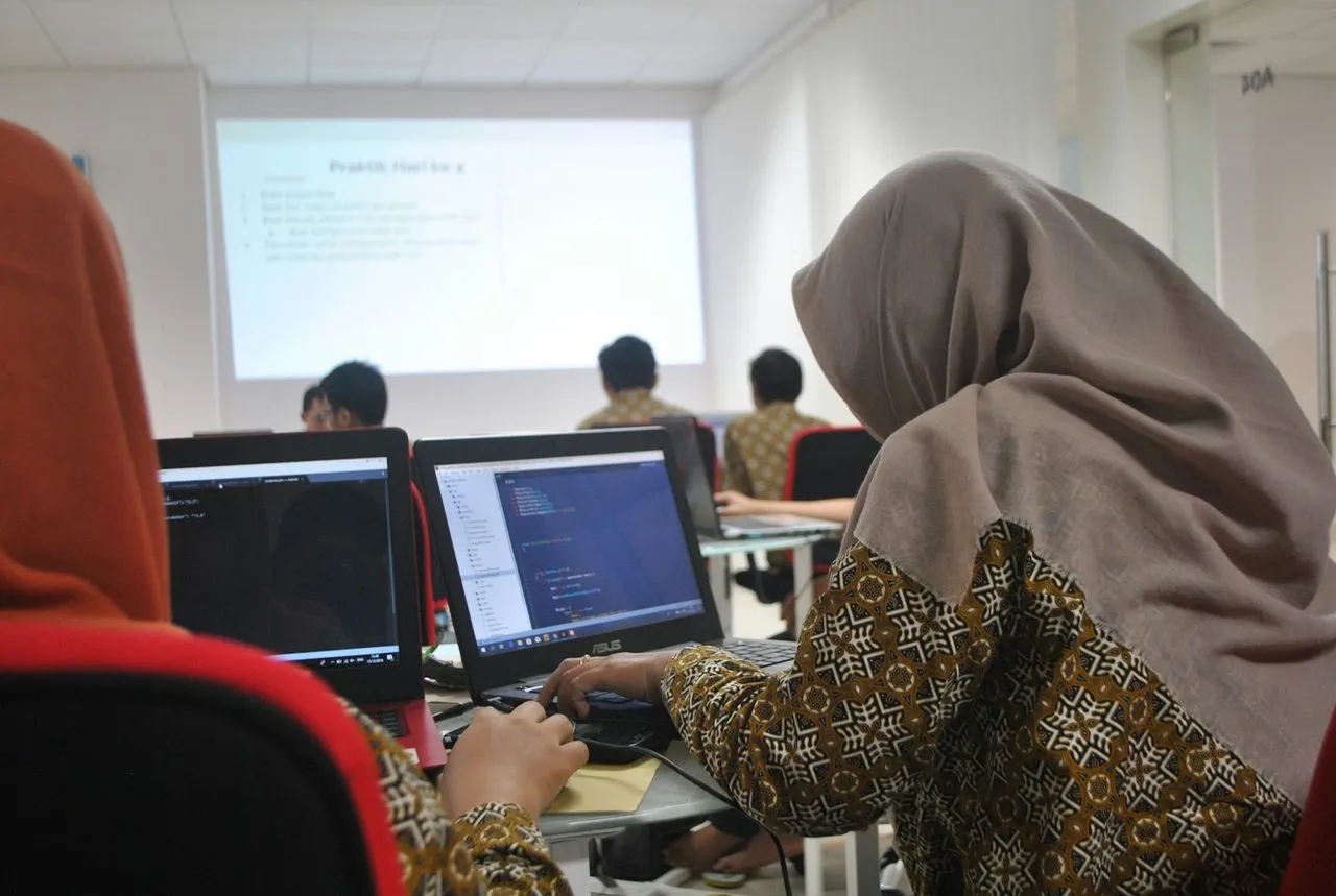 Peserta berhijab mengerjakan latihan di komputer pada kelas pelatihan