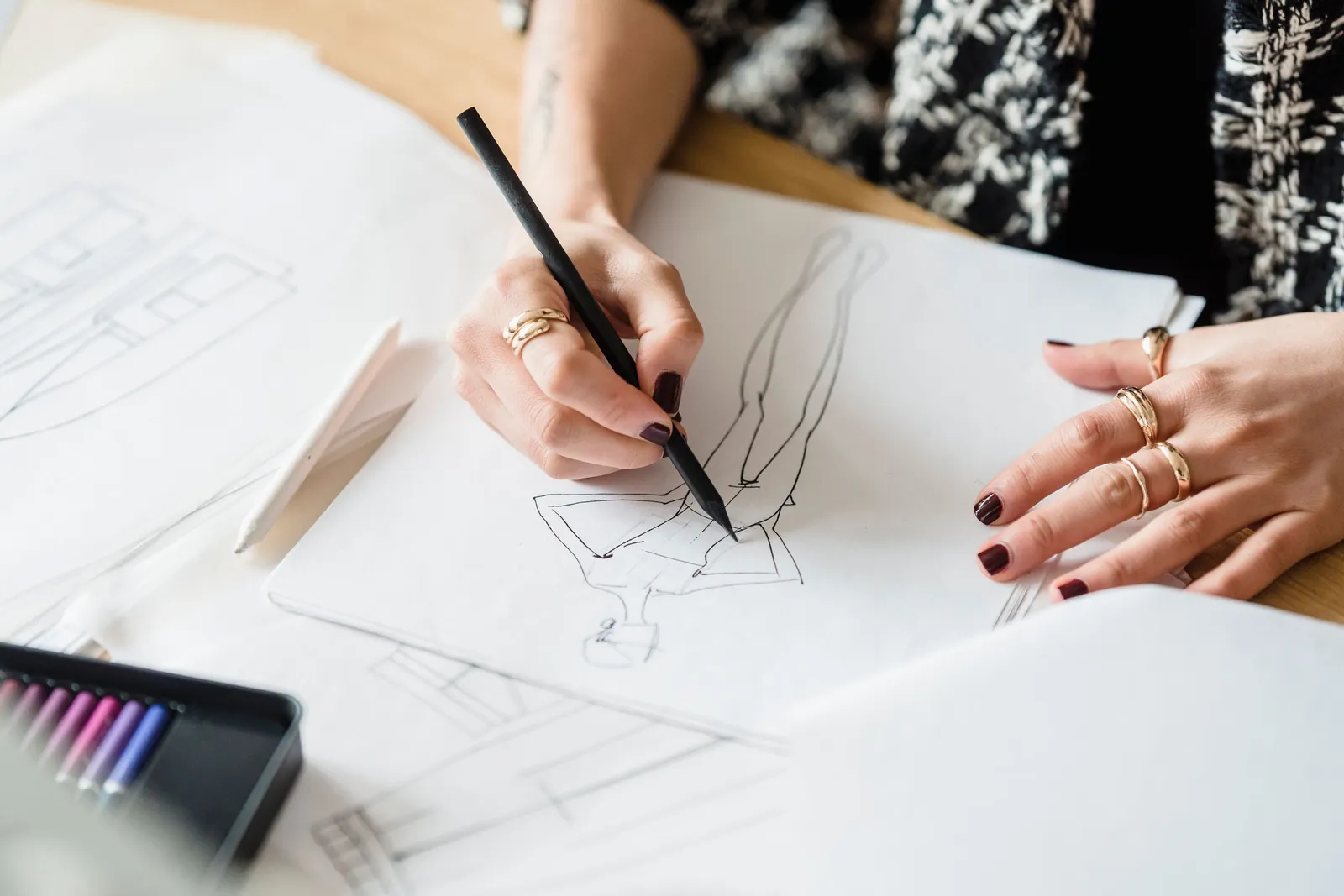Tangan perancang membuat sketsa di atas kertas