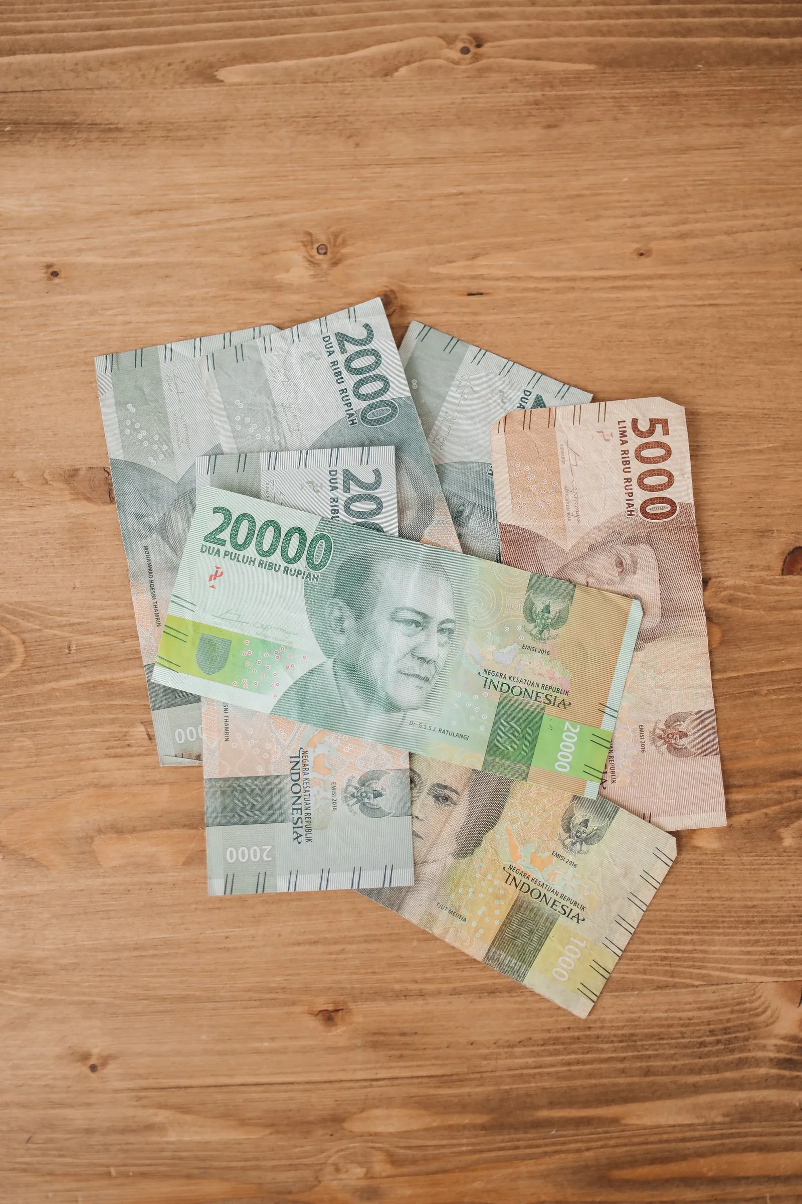 Uang kertas rupiah di atas meja kayu