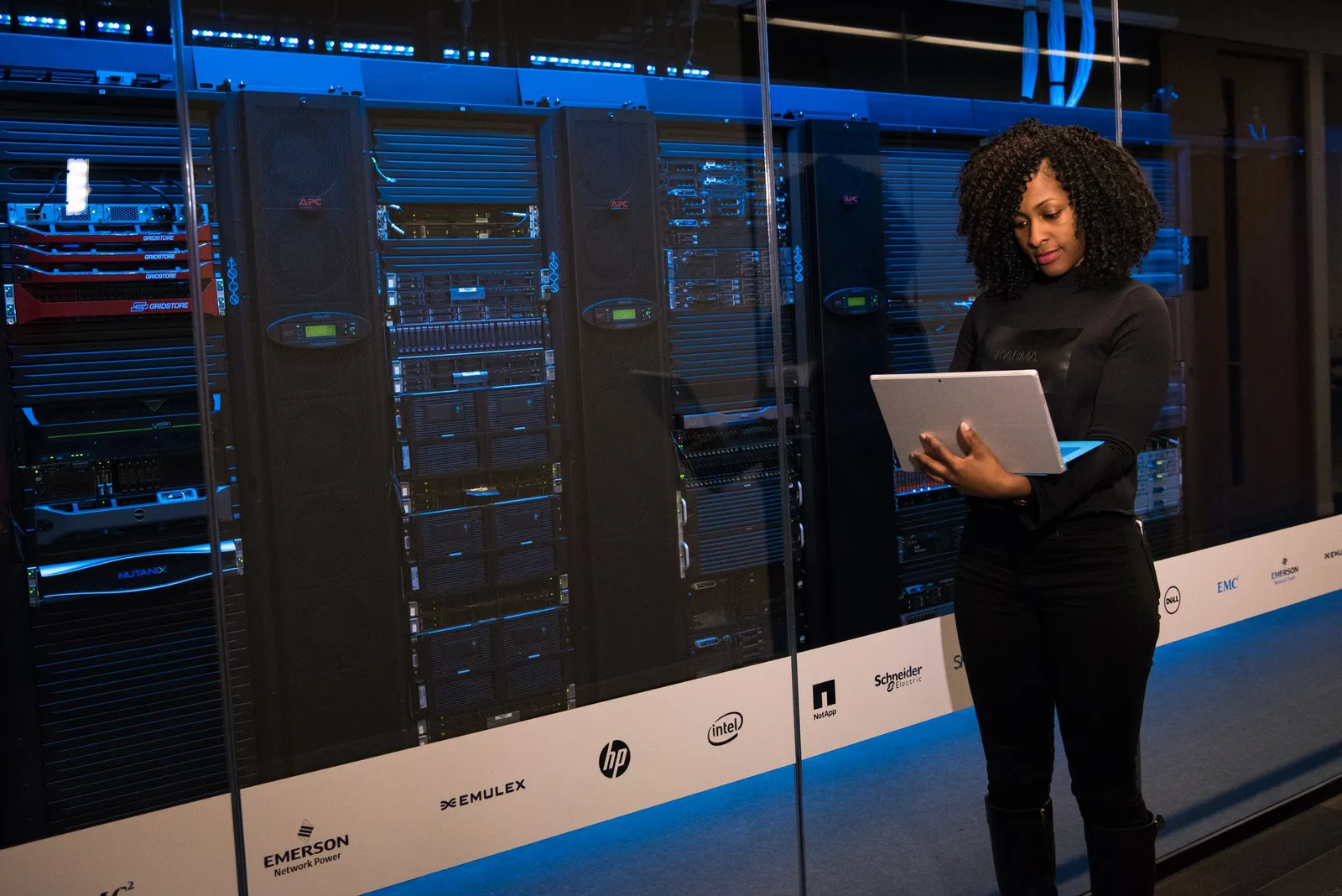Teknisi perempuan memantau server dengan laptop
