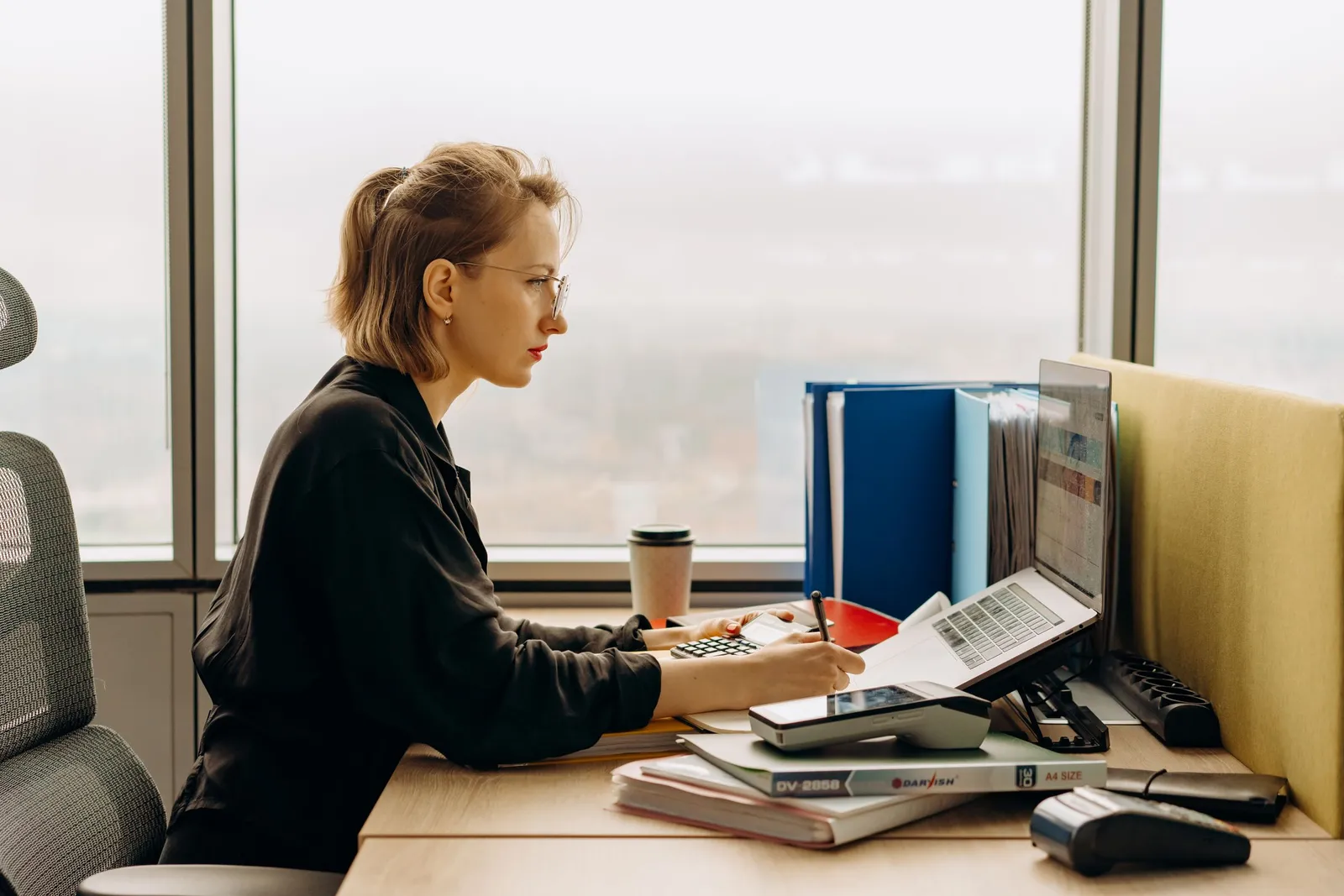 Perempuan bekerja di laptop di meja kantor