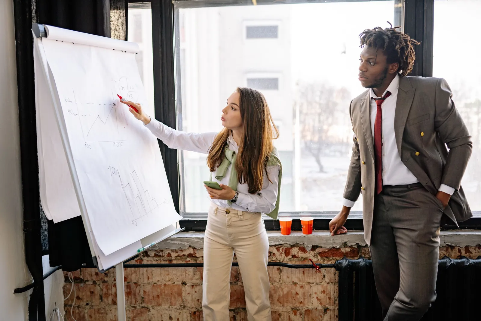 Perempuan memaparkan rencana di papan flipchart