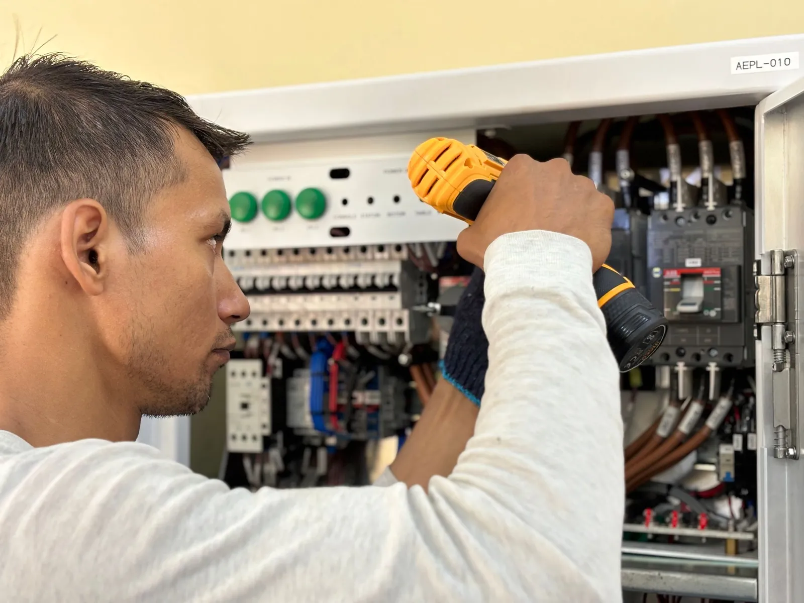 Teknisi listrik bekerja di panel kelistrikan