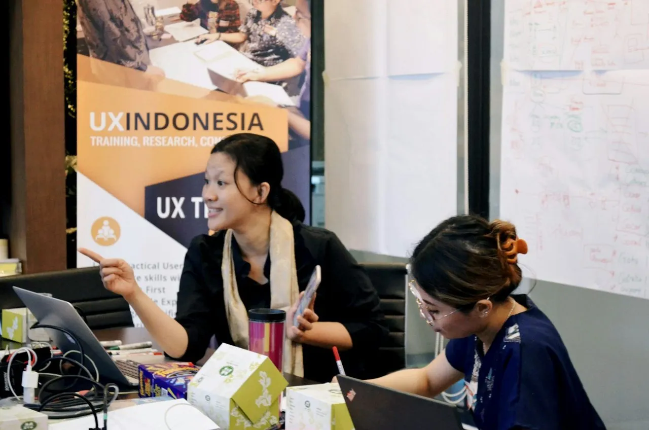 Pemateri mendampingi peserta yang bekerja di laptop