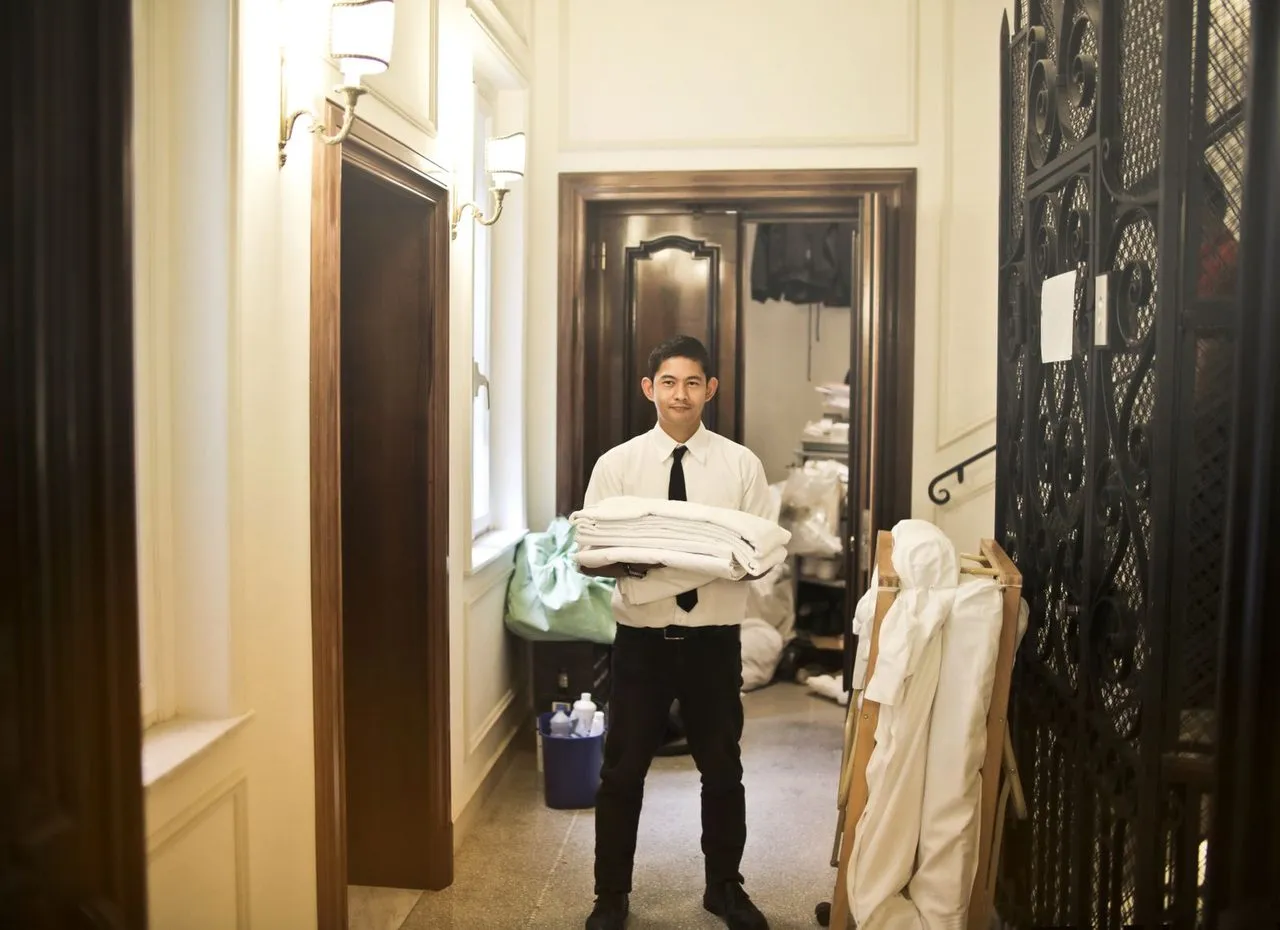Staf hotel membawa linen bersih di lorong