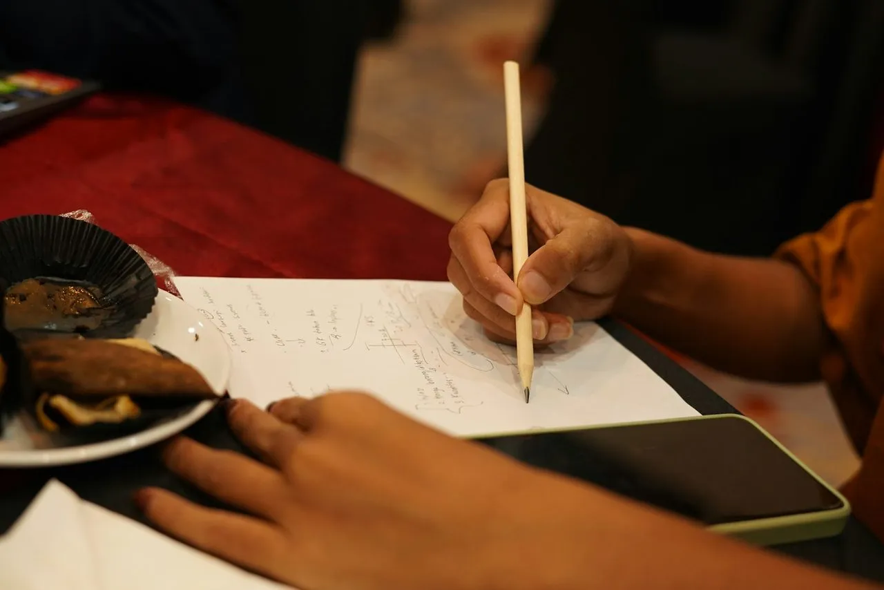 Tangan menulis perhitungan di atas kertas