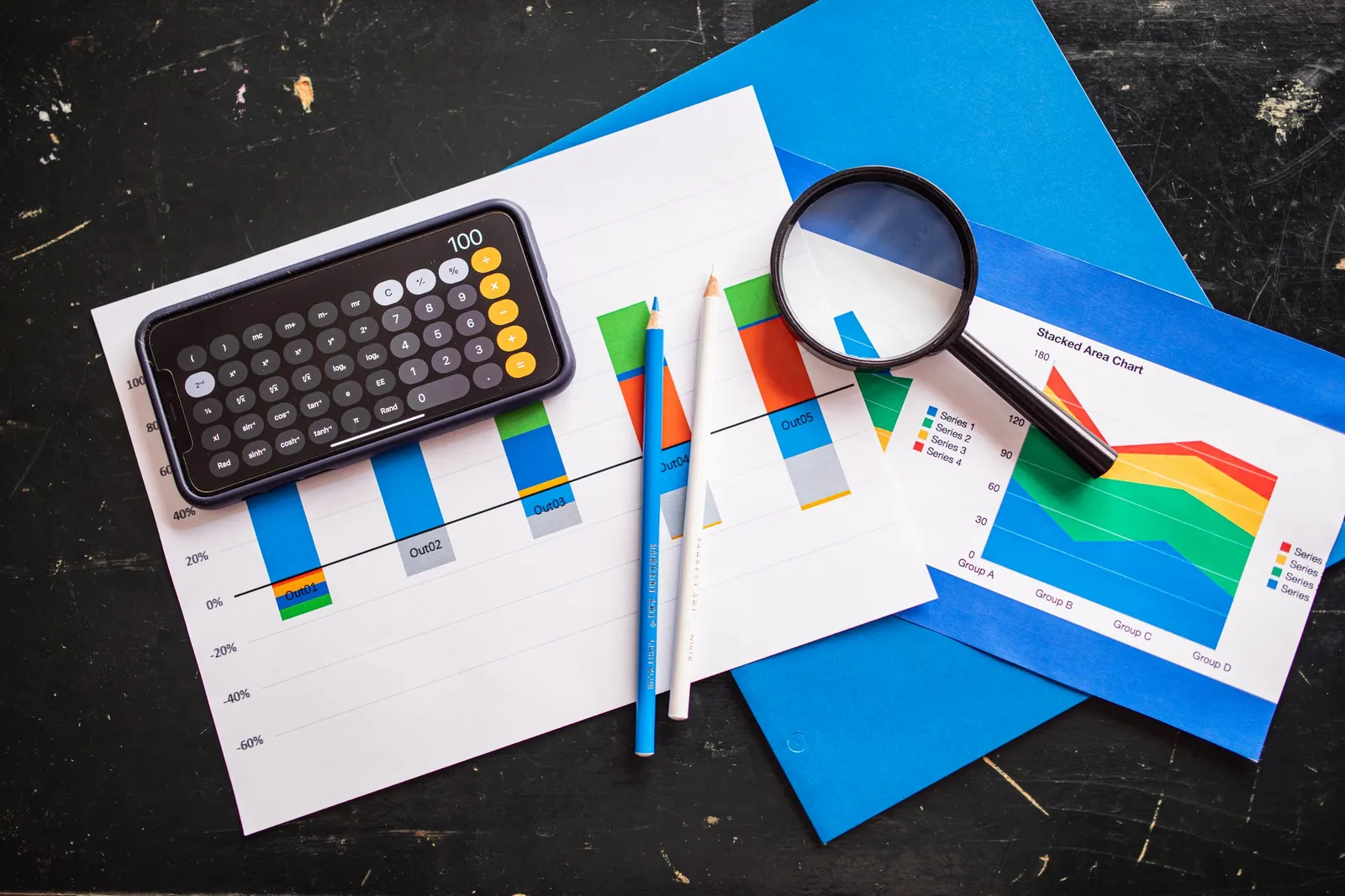Kalkulator dan kaca pembesar di atas kertas grafik batang dan diagram
