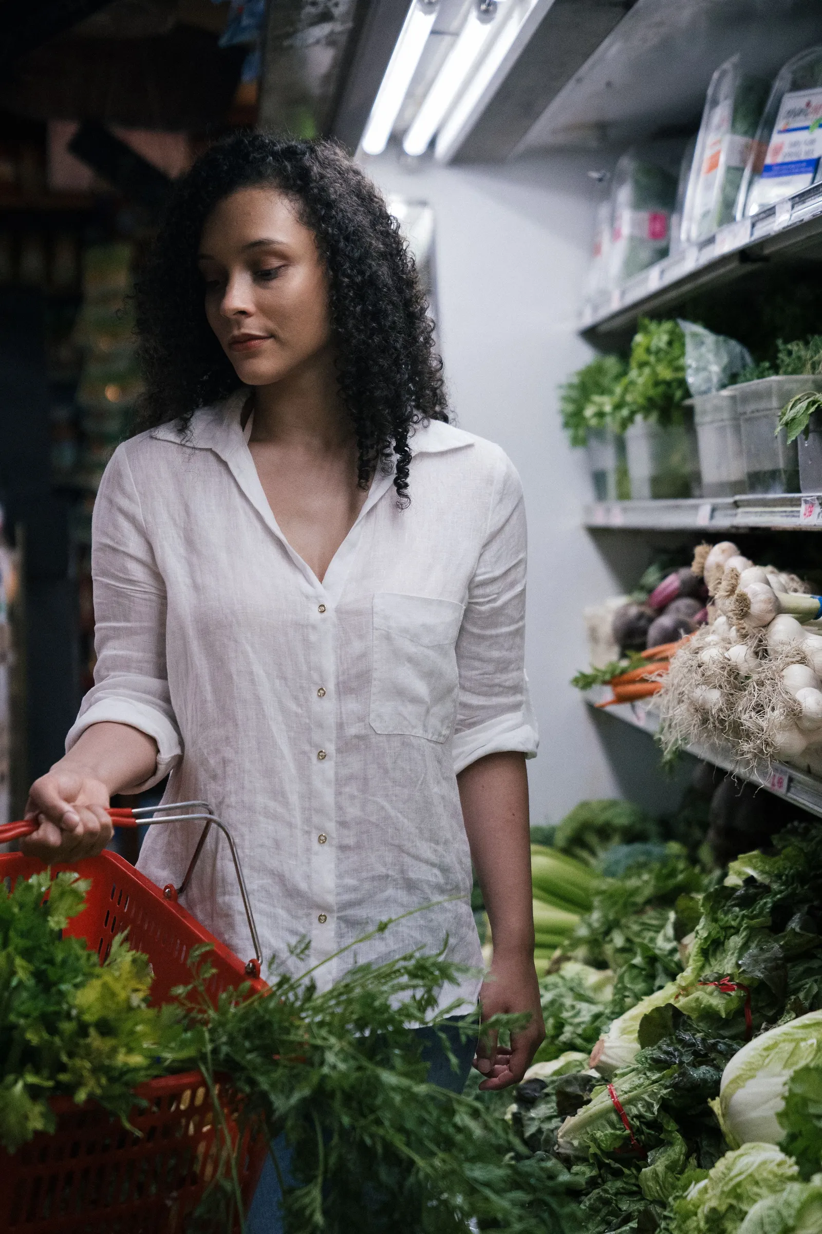 Perempuan membawa keranjang sayur